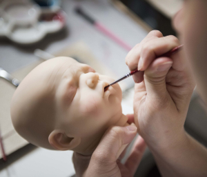 12 May 2019 – Basia paints a new doll, in Olesnica, Poland. It takes a great deal of patience and attention to detail to paint the vinyl so that it looks like human skin.