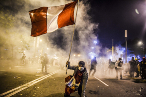 14 November 2020 – A supporter of ousted president Martin Vizcarra waves a Peruvian flag on Avenida Abancay, in Lima, Peru, in demonstrations that continued past the 11pm curfew imposed due to the COVID-19 pandemic.