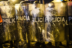 12 November 2020 – Police form a blockade to prevent protesters from reaching the Peruvian Congress building in Lima, Peru, while the protesters throw paint.