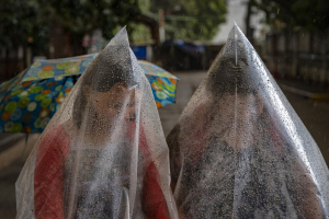 12 January 2020 – Residents of the town of Talisay in Batangas, Philippines, use plastic bags to shield themselves from ash mixed with rainwater, as the volcano erupts.