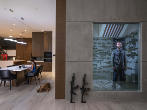 16 April 2019 – Robert Baldwin Jr stands in his secret gunroom, behind a one-way mirror in his home in Las Vegas, Nevada, USA. His girlfriend, Tori, sits at the table. Robert received his first gun—a .22-caliber rifle—as a gift from his father when he was six.