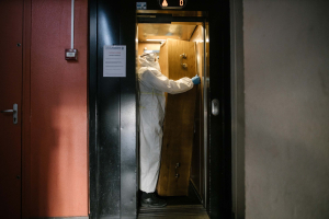 23 April 2020 – A morgue employee transports a coffin from the fifth floor of an apartment block, in the Parisian suburb of Pantin.
