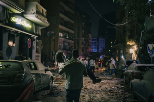 4 August 2020 – A woman is carried to safety in the devastated Gemmayzeh neighborhood, an historic, predominantly Christian quarter of the city with a high concentration of old buildings. On the first night after the explosion, many cars were unusable and roads were blocked by debris, so injured people had to walk or be moved on foot to safer areas of the city.