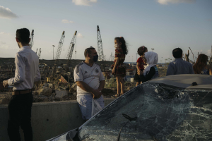 9 August 2020 – Families gather in the evening to observe the extent of the wreckage caused by the blast in the port area of Beirut, Lebanon, from a highway that leads into the city.