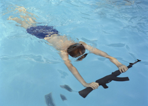 7 August 2020 – Mateusz practices swimming with a weapon, at a summer military camp in Mrzeżyno, Poland.
