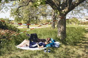 25 April 2020 – Sabrina from Basel in Switzerland and Davor from Wiesbaden in Germany lie on a blanket they have divided with a black line, placed under a border tape in Riehen, Switzerland.
