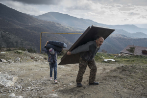 30 November 2020 – Murad Mvrgaryan and his son Vahak carry items from their home before leaving Lachin, Nagorno-Karabakh, the final district to be returned to Azerbaijani control following the November peace agreement.