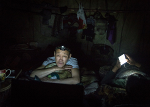 24 October 2020 – Grigory Zamyatin, a hunter, watches a movie on his laptop in his tent, before going to sleep, in Sakha, Russian Federation.