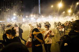 12 November 2020 – People flee tear gas during a protest in front of the Justice Palace in Lima, Peru.