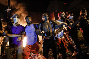 28 May 2020 – Protesters join arms in defiance during a demonstration outside the burning Minneapolis Police Department 3rd Precinct building, in Minneapolis, Minnesota, USA.