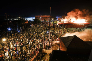 28 May 2020 – Protesters demonstrate outside of the burning Minneapolis Police Department 3rd Precinct, Thursday, in Minneapolis, Minnesota, USA. Surrounding buildings burn after authorities vacated the area before marches converged outside the precinct.